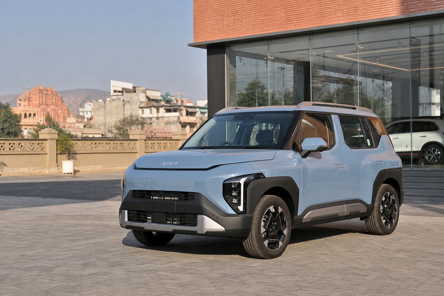Kia Syros finance Jaipur hero image showing the SUV outside a Jaipur dealership for buyers planning down payment, EMI comfort, and booking readiness.