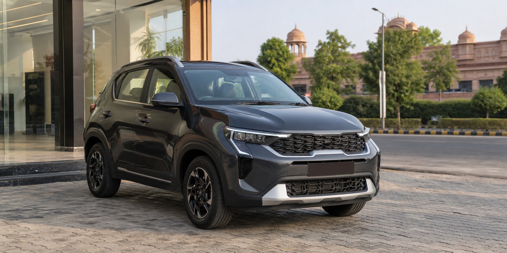 Kia Sonet test drive Jaipur hero showing a graphite compact SUV outside a Jaipur dealership before a buyer decision drive.